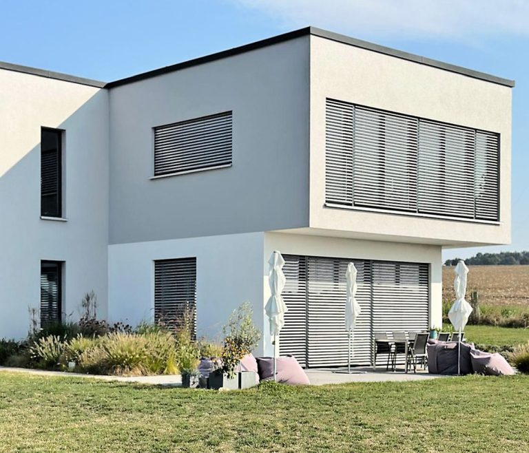 modern gestaltete Fassade eines Neubaus in Grau und Weiß